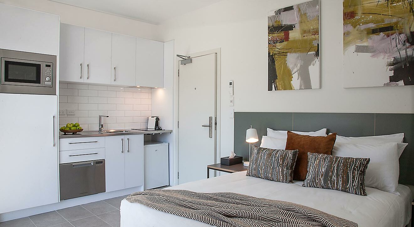 Sojourn-Petite- double- bedroom- apartment- bed-and-kitchen | Sojourn®